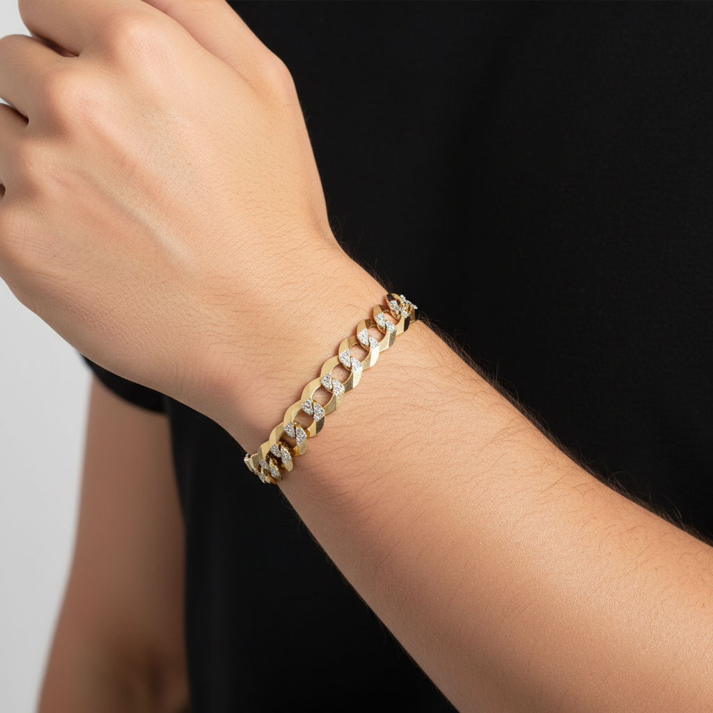 A close-up of a person's wrist wearing a gold chain bracelet with small clear stones, against a black shirt background.