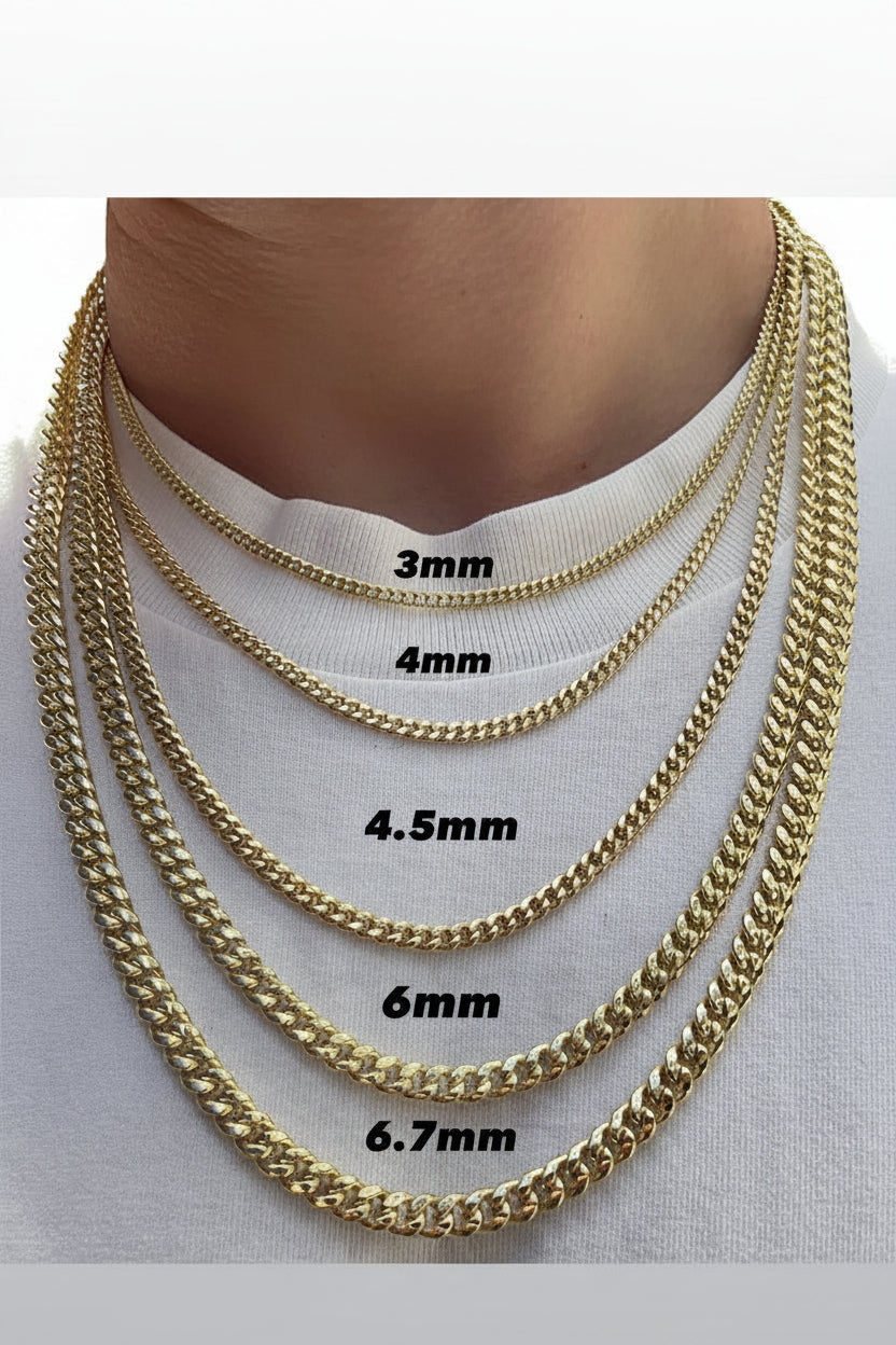 Gold chain necklaces of different widths displayed on a person's neck.
