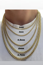 Gold chain necklaces of different widths displayed on a person's neck.