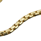 A close-up of a polished yellow gold chain with a textured, elongated link design, set against a dark, solid background.